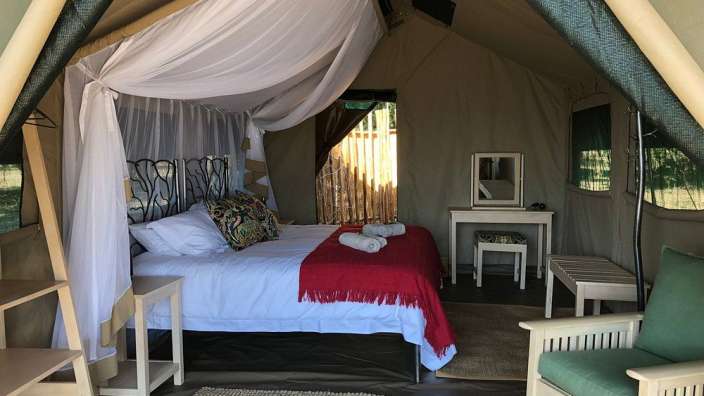 Das Innere eines Zeltes mit einem Bett und einem Stuhl