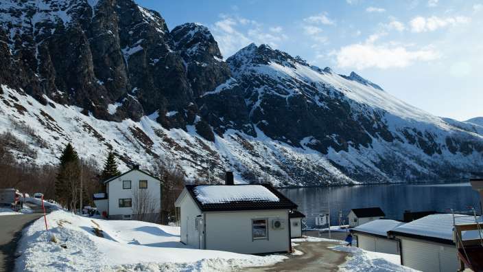 Ein kleines weißes Haus steht inmitten einer schneebedeckten Landschaft