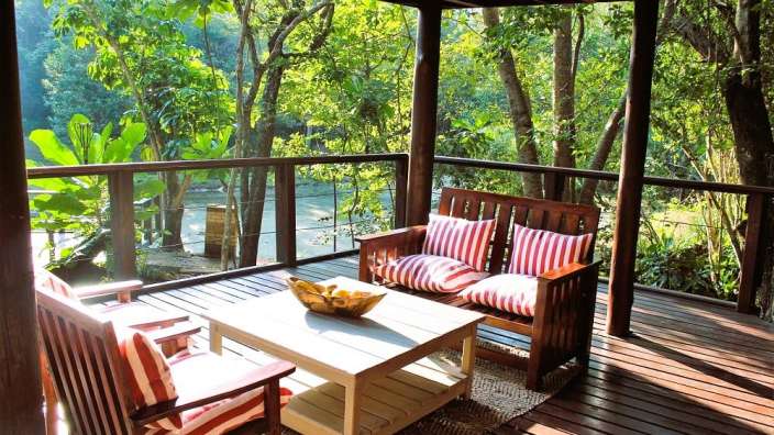 Ein Wohnzimmer auf einem Holzdeck mit einem Tisch und Stühlen