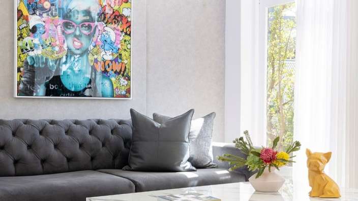 Ein Wohnzimmer mit einem Gemälde an der Wand und einem Couchtisch