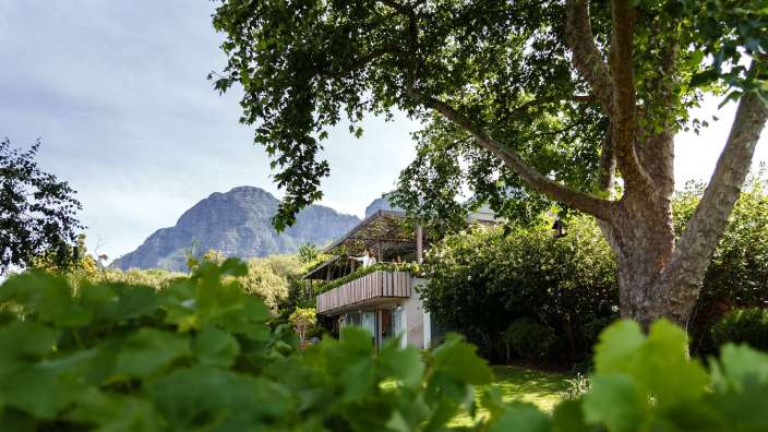 Ein Haus mit einem Balkon und einem Berg im Hintergrund