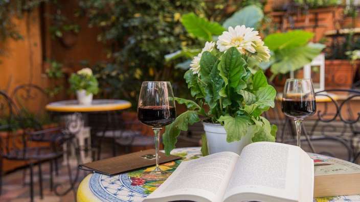 Ein Tisch mit einem Buch und zwei Gläsern Wein
