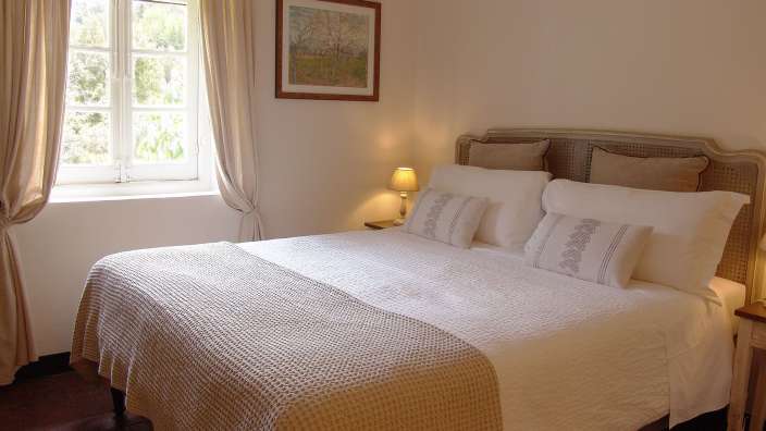 Ein Schlafzimmer mit einem Bett und einem Gemälde an der Wand