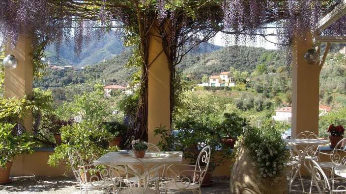 Ein Tisch und Stühle auf einer Terrasse mit Blick auf die Berge