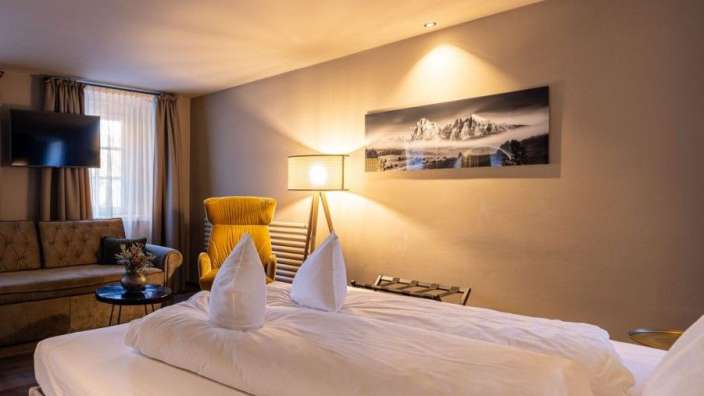 Ein Hotelzimmer mit einem Bett und einem Gemälde an der Wand