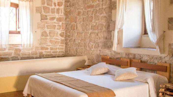 Ein Schlafzimmer mit einem Bett und einer Steinmauer