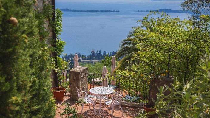 Ein Tisch und Stühle auf einem Balkon mit Blick auf einen See