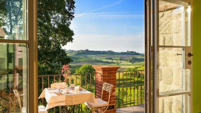 Ein Tisch und Stühle auf einem Balkon mit Blick auf die Landschaft