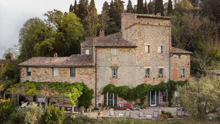 Ein großes Steingebäude mit einer roten Bank davor