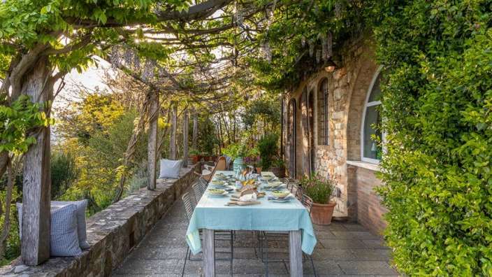 Ein Tisch mit einem blauen Tischtuch auf einer Terrasse
