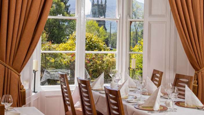 Ein Esszimmer mit einem Tisch und Stühlen und einem Fenster