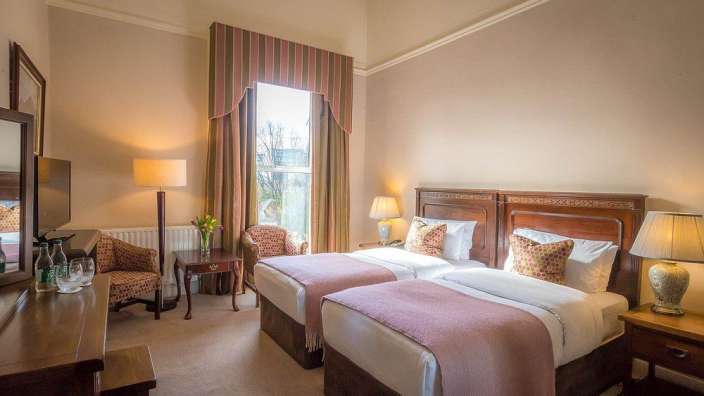 Ein Hotelzimmer mit zwei Betten und einem Stuhl