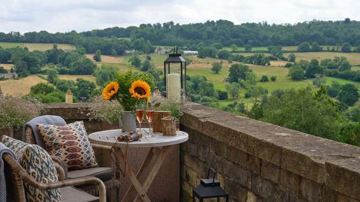 Auf einem balkon steht ein tisch mit blumen und kerzen