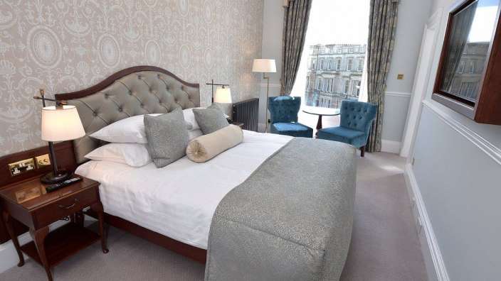 Ein Hotelzimmer mit einem Bett und zwei Stühlen