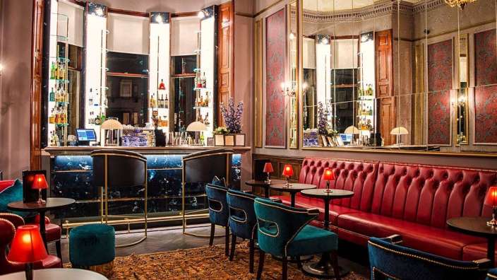 Ein Wohnzimmer mit roten und blauen Möbeln und einer Bar