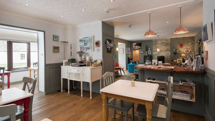 Ein Esszimmer mit Tischen und Stühlen und einer Bar