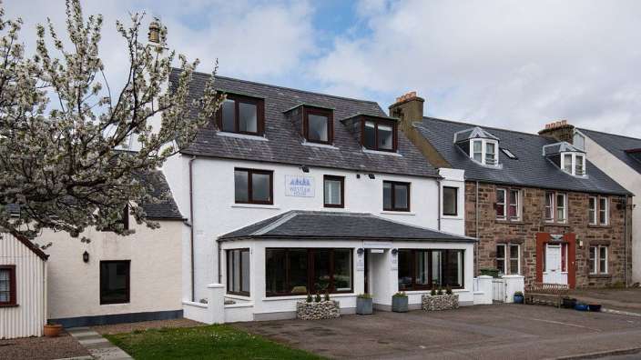 Ein weißes Gebäude mit einem Schild darauf, das anna house sagt