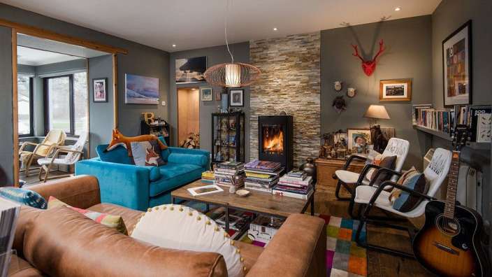 Ein Wohnzimmer mit einem blauen Couch und einer Gitarre