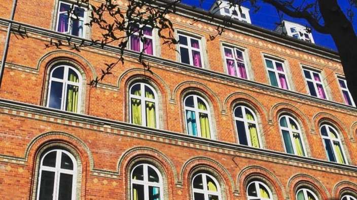 Ein großes Backsteingebäude mit vielen bunten Fenstern