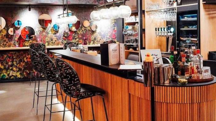 Eine Bar mit Stühlen und Flaschen an der Theke