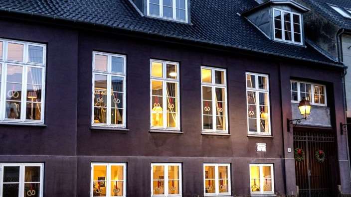 Ein lila Gebäude mit vielen weißen Fenstern