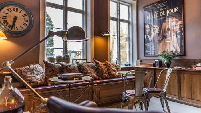 Ein Wohnzimmer mit einer Uhr und einem Poster für belle de jour