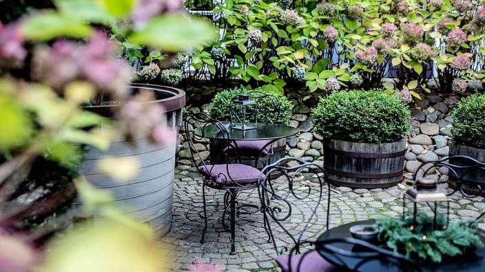 Ein Tisch und Stühle auf einem Steinterrassenplatz