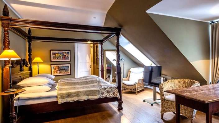 Ein Schlafzimmer mit einem Himmelbett und einem Tisch