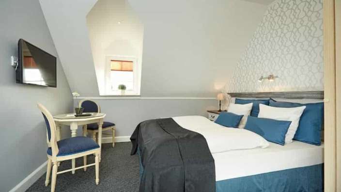 Ein Hotelzimmer mit einem Bett, einem Tisch und einem Fernseher