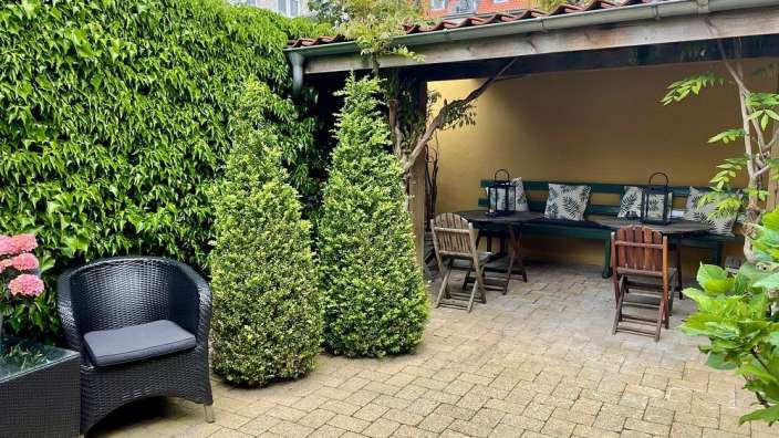 Eine Terrasse mit Stühlen und einem Tisch mit Kissen darauf