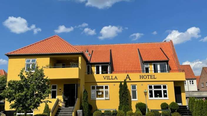 Ein gelbes Gebäude mit der Aufschrift villa a hotel darauf