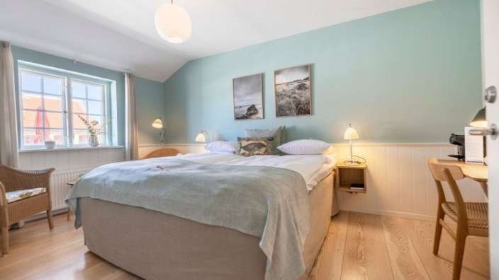 Ein Schlafzimmer mit einem Bett und zwei Bildern an den Wänden