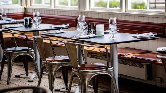 Eine Reihe von Tischen und Stühlen in einem Restaurant