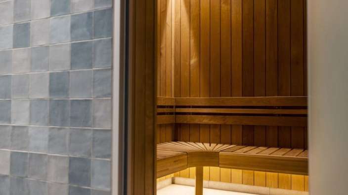 Eine Holzsauna mit blauen Fliesen an der Wand