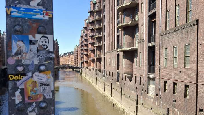 Eine Reihe von Aufklebern auf einem Säulen neben einem Fluss mit der Aufschrift delo darauf