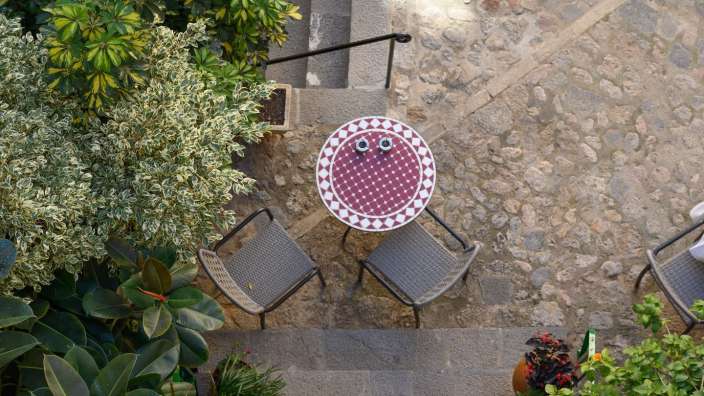 Ein rot-weiß gemusterter Tisch mit zwei Stühlen darauf