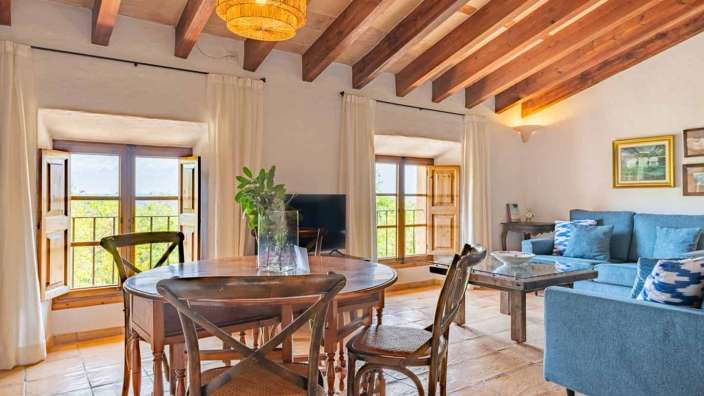 Ein Wohnzimmer mit einem Tisch und Stühlen und einem Fernseher