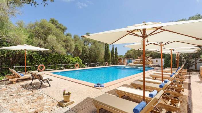 Liegestühle und Sonnenschirme um einen großen Swimmingpool