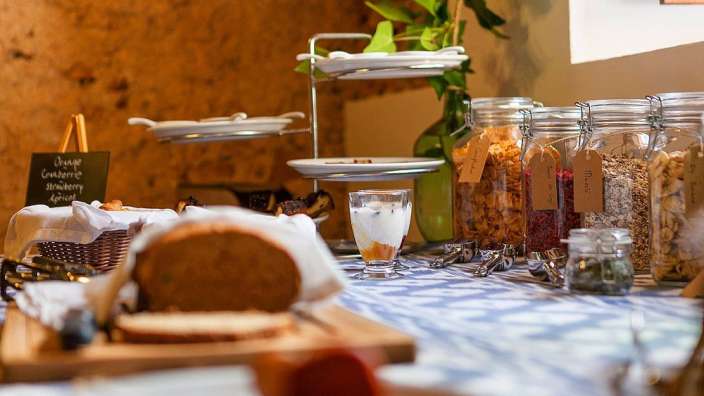 Ein buffettisch mit verschiedenen getränken und einer tafel mit einem schild , auf dem steht " orange granola "