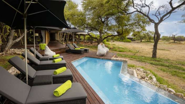 Liegestühle und Sonnenschirme umgeben einen großen Swimmingpool