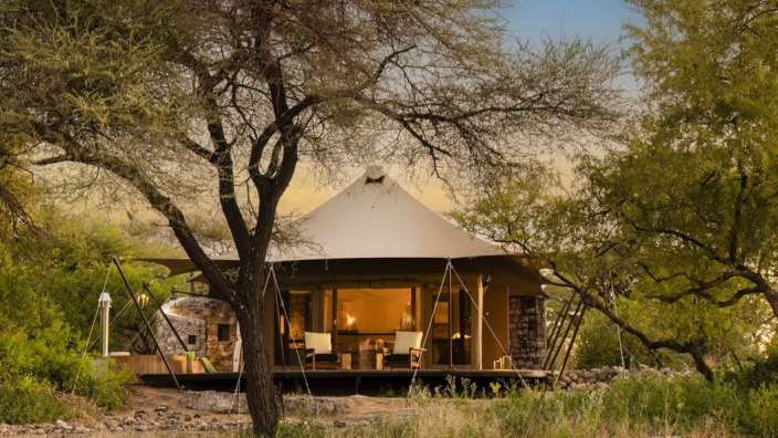 Ein weißes Zelt steht inmitten einer üppigen grünen Landschaft