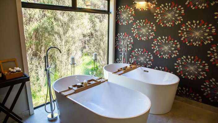 Ein Badezimmer mit zwei Badewannen und einem großen Fenster