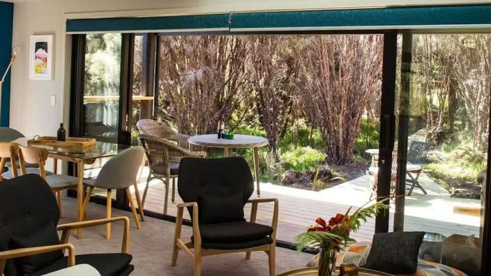 Ein Wohnzimmer mit vielen Stühlen und einem Tisch