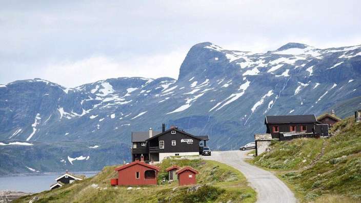 Eine Straße führt zu einem schwarzen Gebäude mit der Aufschrift " bergen lodge "