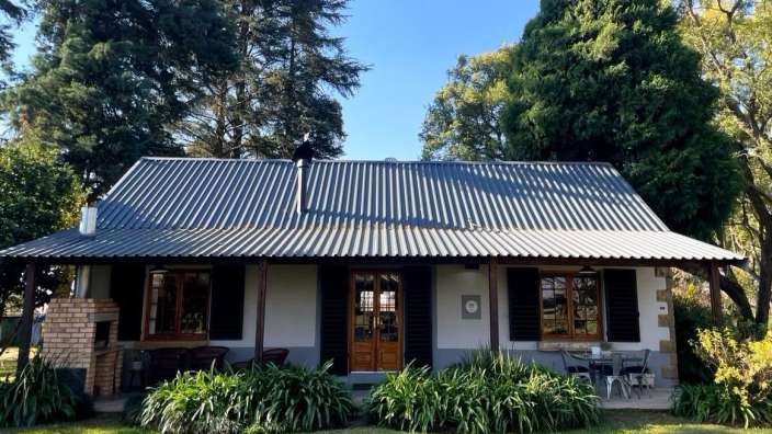 Ein kleines Haus mit einem Metalldach und einem Grill