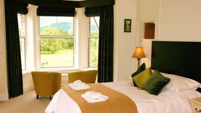 Ein Schlafzimmer mit einem Bett und zwei Stühlen