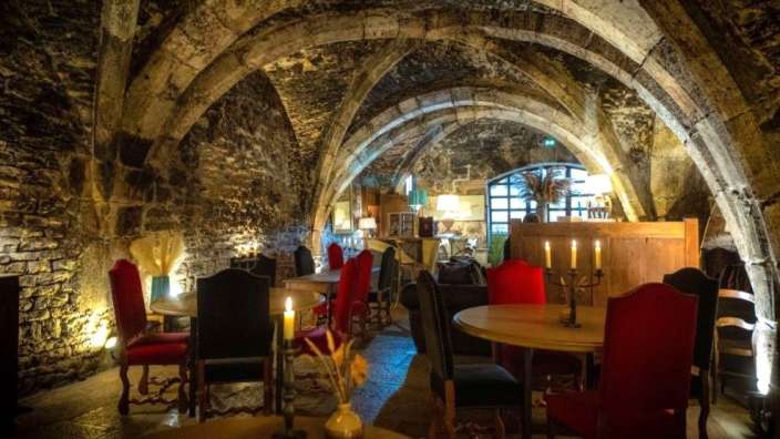 Eine Reihe von Tischen und Stühlen mit Kerzen in einem dunklen Raum