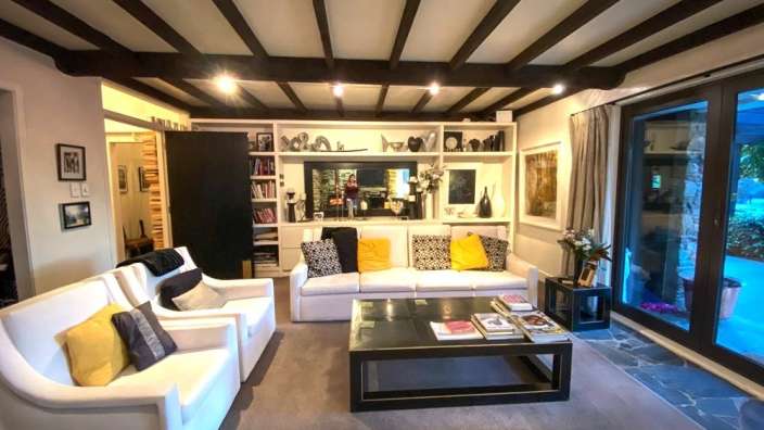 Ein Wohnzimmer mit weißen Möbeln und einem schwarzen Tisch