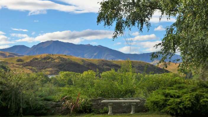 Eine Bank in einem Garten mit Blick auf die Berge