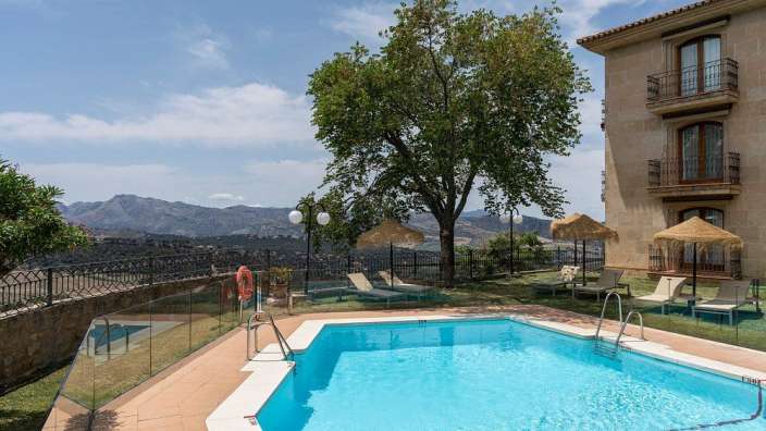 Ein großer Swimmingpool vor einem Gebäude mit Blick auf die Berge
